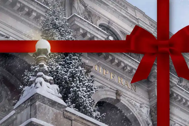 Ett vintrigt operahus med gran på terrassen, inslaget med ett rött snöre.