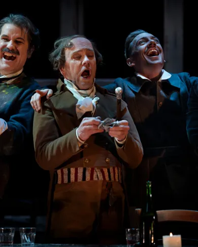A group of men singing and laughing stand next to each other.