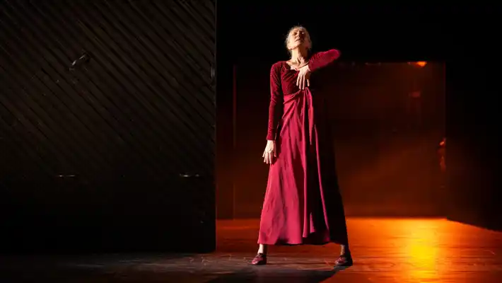 A woman in a red dress standing on a stage.