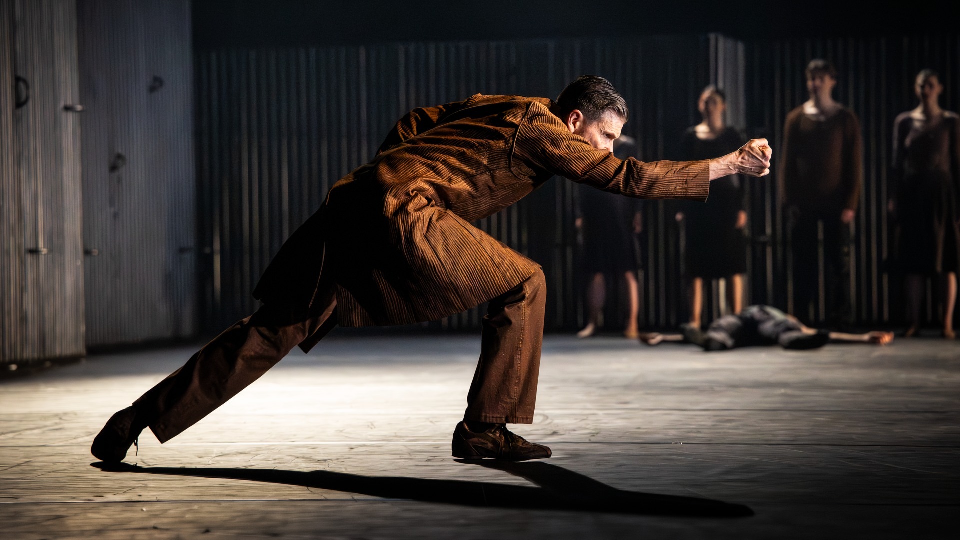A man in a brown suit is dancing.