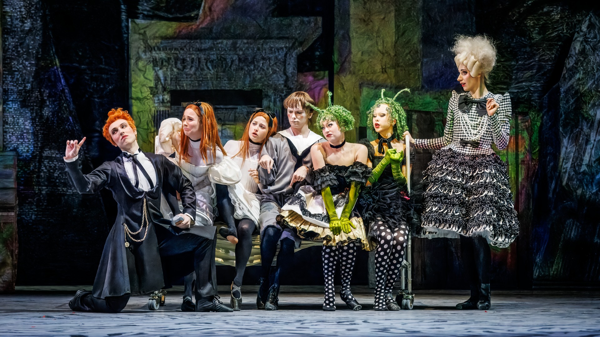 En grupp människor som trängs sittandes på en säng.