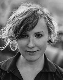 En närbild på en kvinna med slarvigt uppsatt ljust hår.