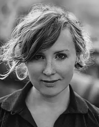 En närbild på en kvinna med slarvigt uppsatt ljust hår.