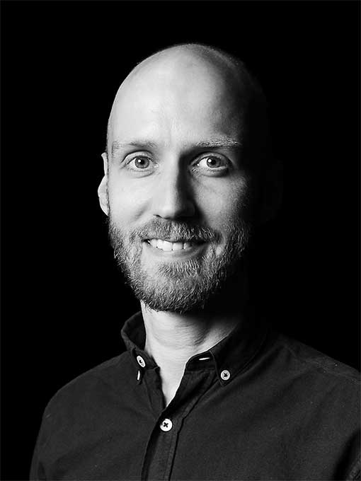 Närbild på en leende, skäggprydd man.