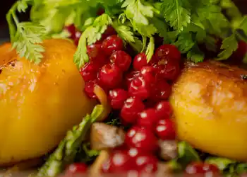Close-up of food: potato cakes, lingonberries and parsley.