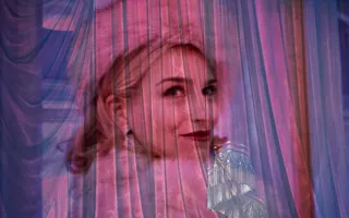 A woman in a fur hat is projected onto a curtain.