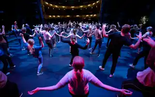 En stor grupp människor som dansar på en scen.