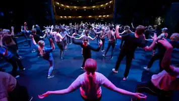 En stor grupp människor som dansar på en scen.