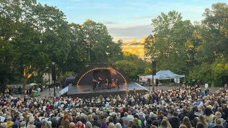 An outdoor stage with a large audience in front.