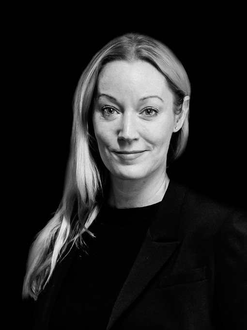 En närbild på en kvinna med långt ljust hår som ligger över ena axeln.