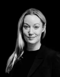 En närbild på en kvinna med långt ljust hår som ligger över ena axeln.