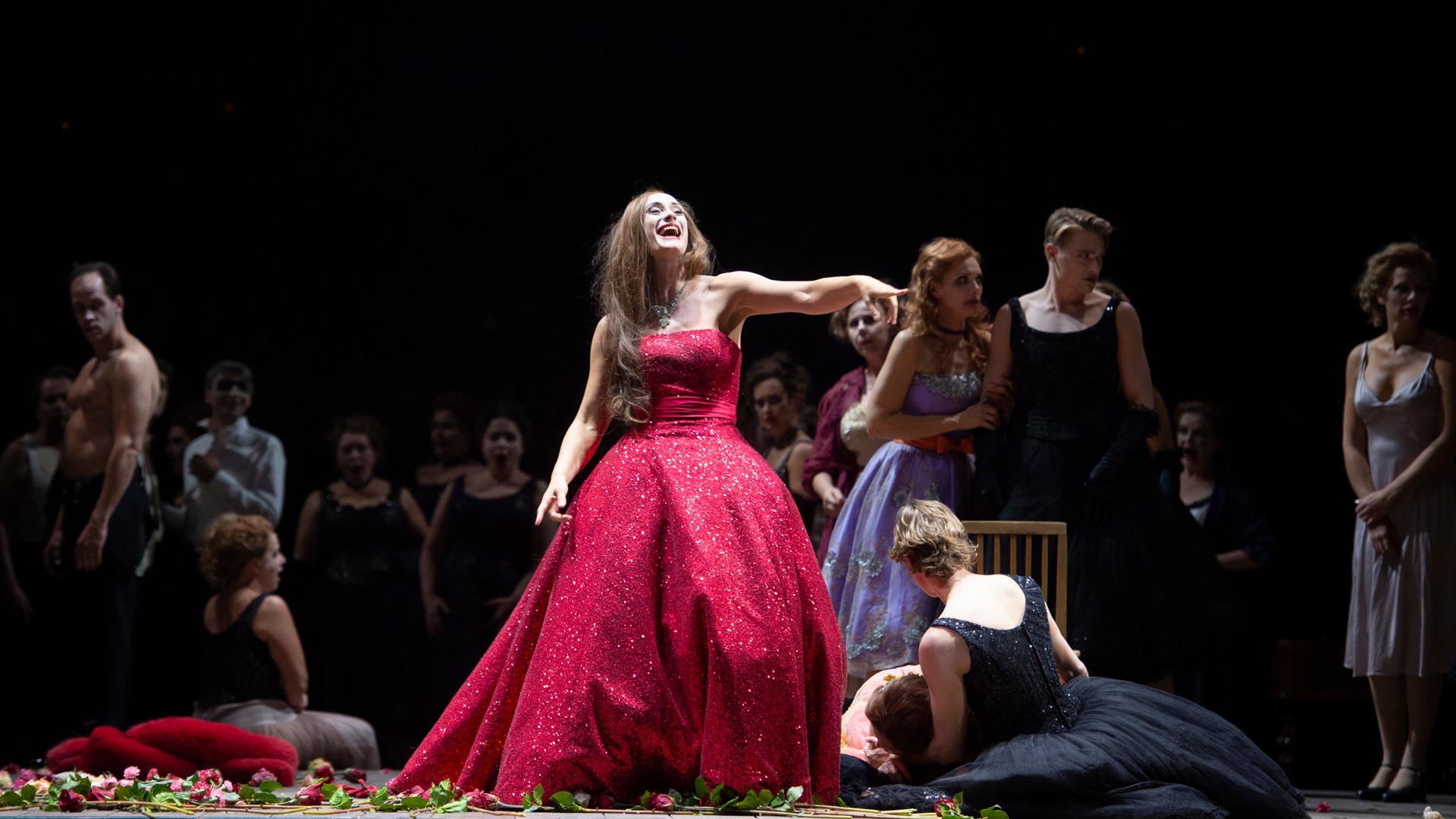 En kvinna i röd klänning på scen.