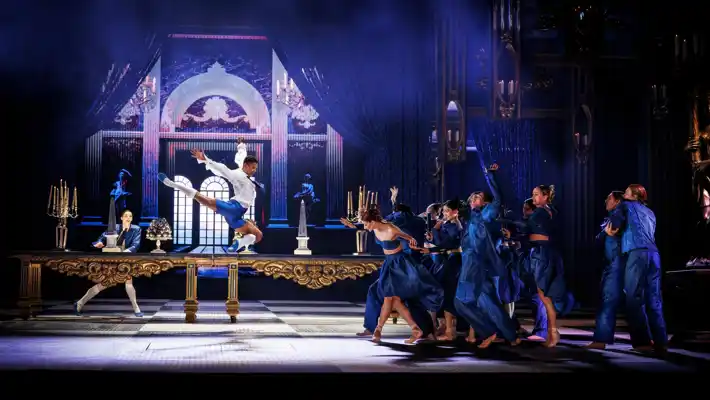 Runt ett stort bord rör sig flera personer: en man gör ett stort över bordet.