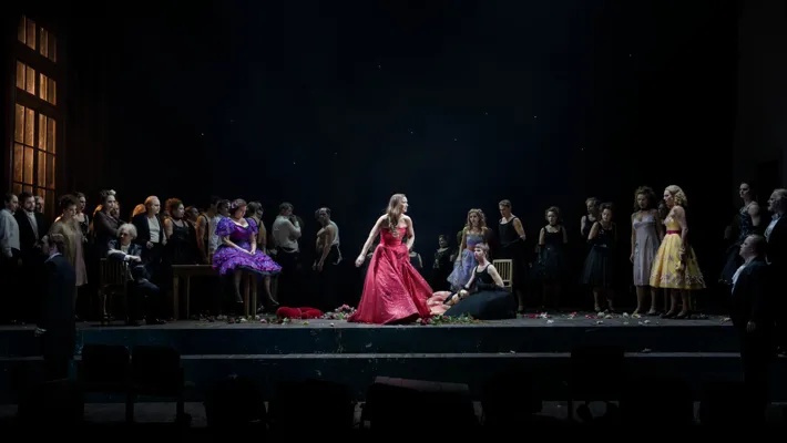 En kvinna i en röd klänning på scenen.