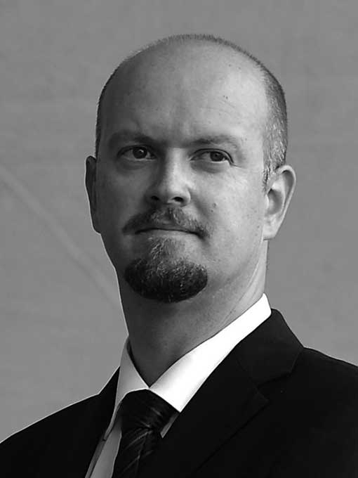 Portrait image of a man wearing a suit and tie.