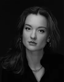 En närbild på en mörkhårig kvinna med med stora ringar som örhängen.