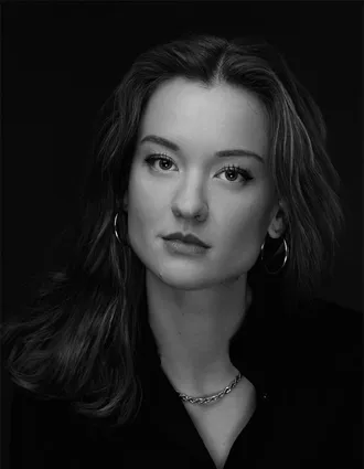 En närbild på en mörkhårig kvinna med med stora ringar som örhängen.