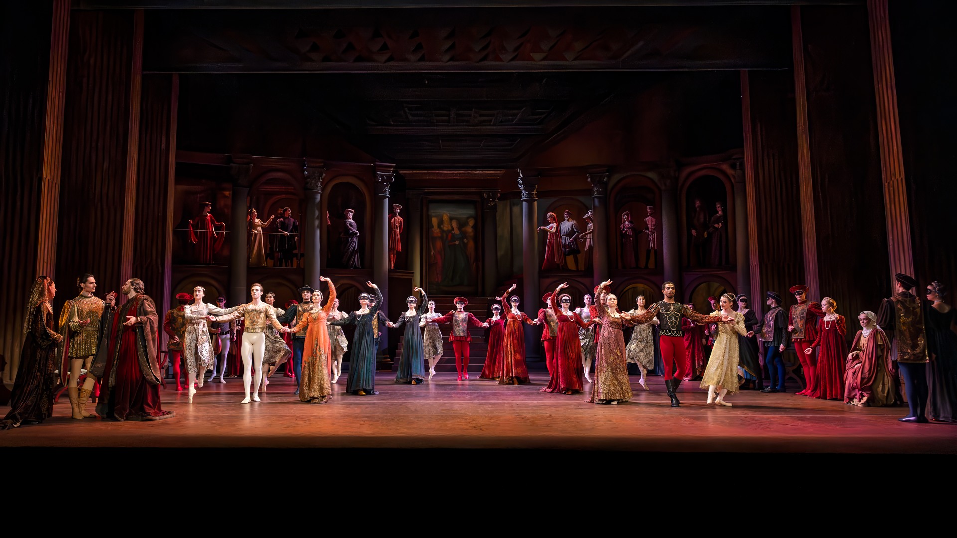 En stor mängd dansare står på en scen i olika poser.