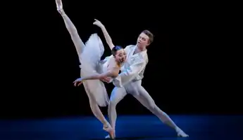 En pas de deux med en manlig och en kvinnlig dansare i vita dräkter.