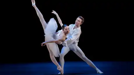 En pas de deux med en manlig och en kvinnlig dansare i vita dräkter.