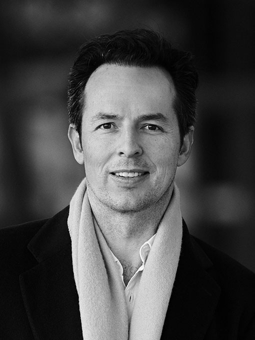 A close-up of a man wearing a shirt and a scarf.