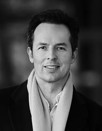 A close-up of a man wearing a shirt and a scarf.