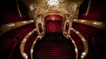 Vy mot en scen från en rikt utsmyckad salong i rött och guld.