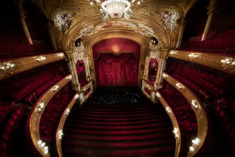 Vy mot en scen från en rikt utsmyckad salong i rött och guld.