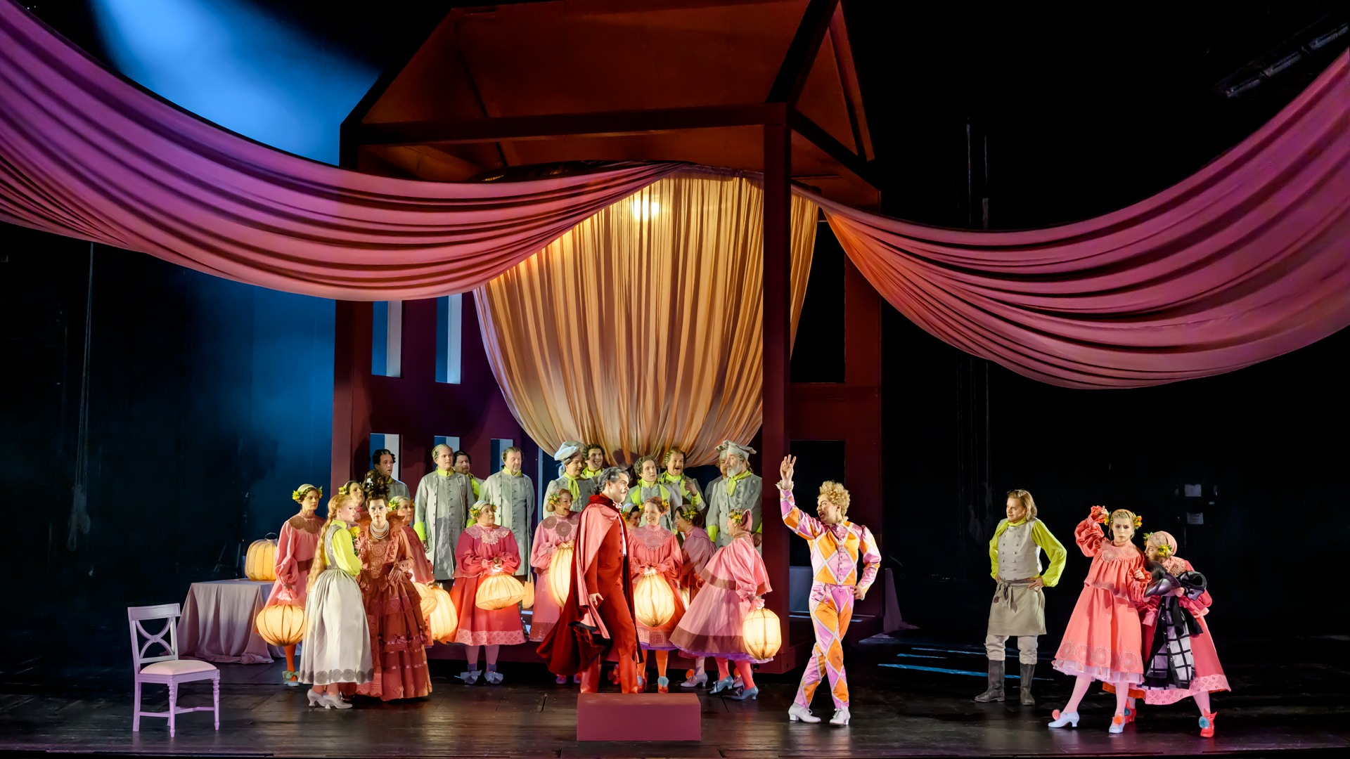 En stor grupp människor med lyktor samlas under en baldakin.