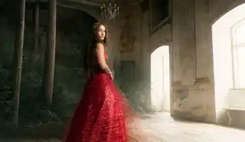 En kvinna i röd klänning står i ett rum med fönster, i vänstra hörnet växer en skog.