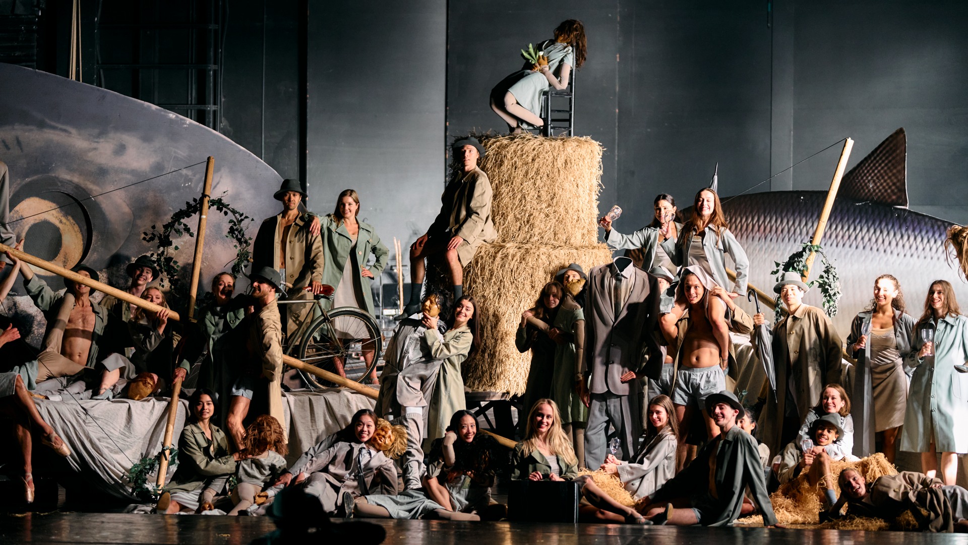 En massa personer på en scen, i mitten stora höbalar, i bakgrunden en stor fisk.