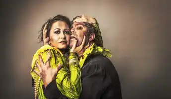 En kvinna och en man är tätt omslingrade, de är smutsiga och kläderna är slitna.