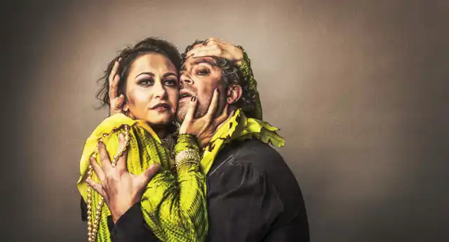 A woman and a man are tightly entwined, they are dirty and their clothes are torn.