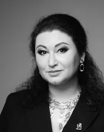 En närbild på en kvinna med mörkt uppsatt hår som har stora smycken på sig.