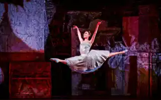 A woman in a white dress makes a big jump.
