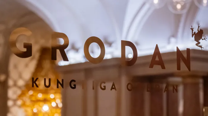 En logotyp klistrad på ett fönster med insyn mot en restaurang.