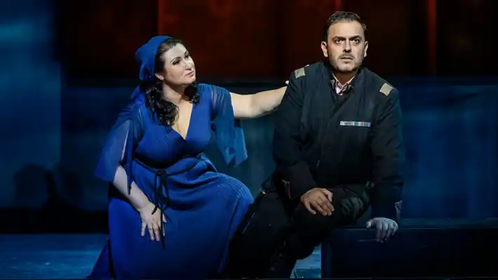A woman dressed in blue extends her arm towards a man in uniform.