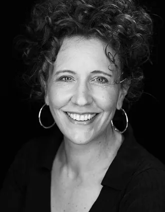 En närbild på en leende kvinna med kort mörkt hår.