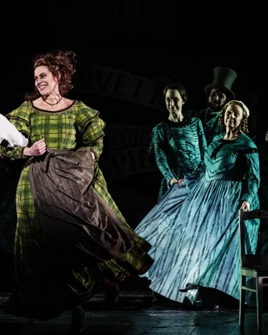 A group of people on a stage, a couple dancing in the foreground.