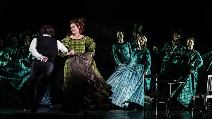 En grupp människor på en scen, ett par dansar i förgrunden.