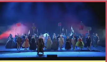 En stor mängd personer står på en scen med olika färgglada kostymer.