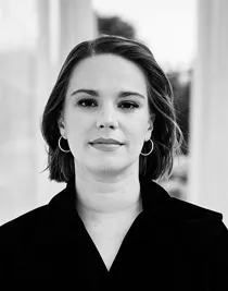 En närbild på en kvinna i mörka kläder, kort pagefrisyr.