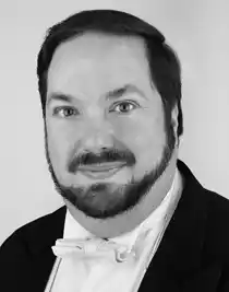 Nn närbild på en man med skägg klädd i frack.