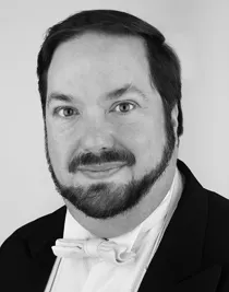 Nn närbild på en man med skägg klädd i frack.