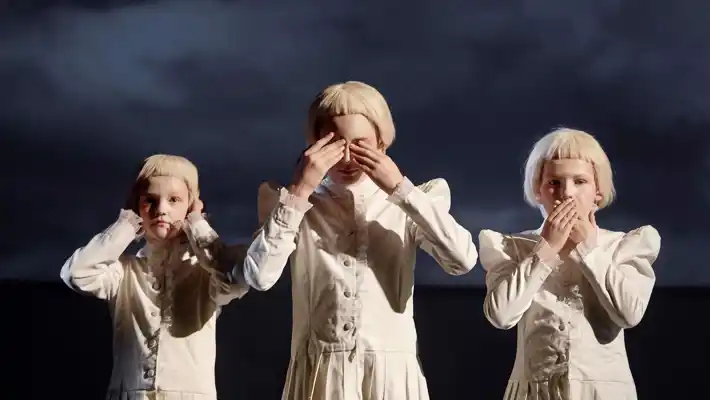 Tre barn i vita kläder, en håller för öronen, en håller för ögonen och en håller för munnen.