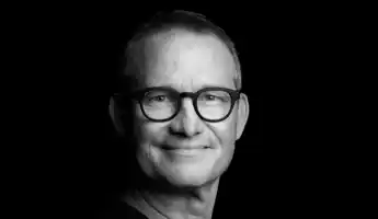 Black and white close-up of a man with dark glasses.