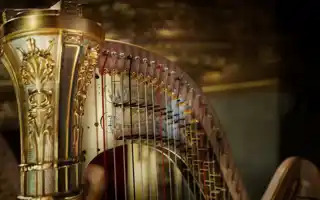 Närbild på överstycket av en guldfärgad harpa.