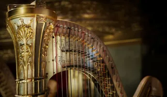 Närbild på överstycket av en guldfärgad harpa.