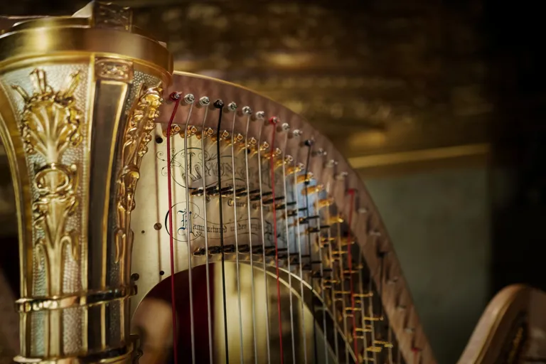 Närbild på överstycket av en guldfärgad harpa.