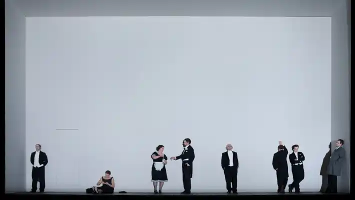 People dressed in black on stage with a white backdrop.